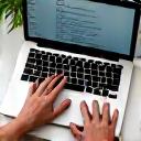 Hand typing an email on a laptop